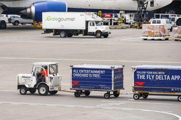 Small tractor unit pulling Delta Air Lines luggage trucks at Seattle Tacoma airport