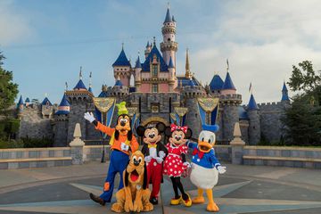 The Disney characters, Goofy, Pluto, Mickey, Minnie and Donald Duck in front of the castle at Disneyland in California