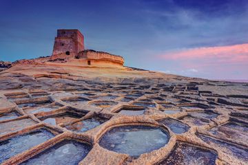 Malta, Gozo Island, Xlendi, watchtower and salt pans at sunset