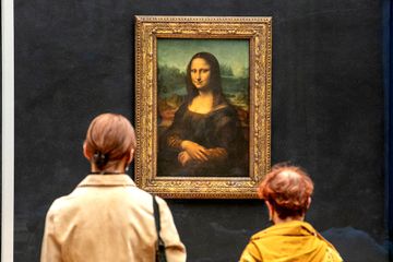 Visitors observe the painting 'La Joconde' The Mona Lisa by Italian artist Leonardo Da Vinci on display in a gallery at Louvre on May 19, 2021 in Paris, France.