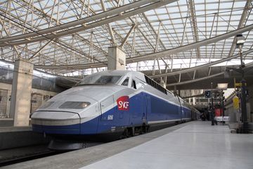 SNCF train with passengers on platform in TGV railway station at Charles De Gaulle International Airport Paris, France