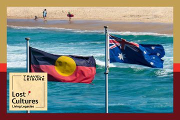 The Australian flag and Australian Aboriginal flag fly side-by-side at Bondi Beach, Sydney in early summer. This image was taken on a windy day in the late afternoon.