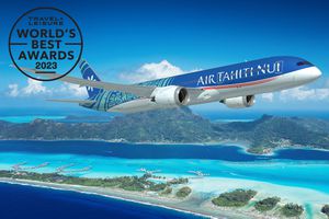 An Air Tahiti Nui airplane flying over an island in French Polynesia 