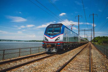 An Amtrak train on the Northeast Regional line traveling past water