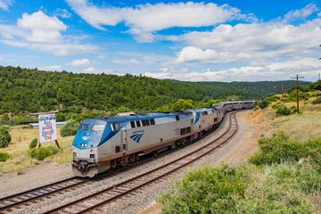An Amtrak train on the Southwest Chief Route traveling past a farm in Santa Fe