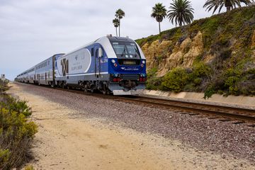 Amtrak Pacific Surfliner traveling south on rail tracks through Del Mar, California.
