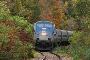 The Amtrak Vermonter on a winding track surrounded by fall foliage 