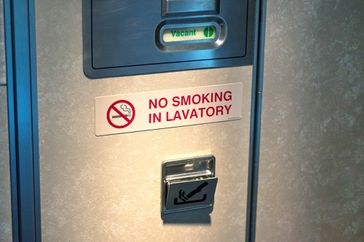Door of Vacant lavatory in airplane with No smoking sign