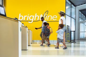 A family walking through a Brightline train station 
