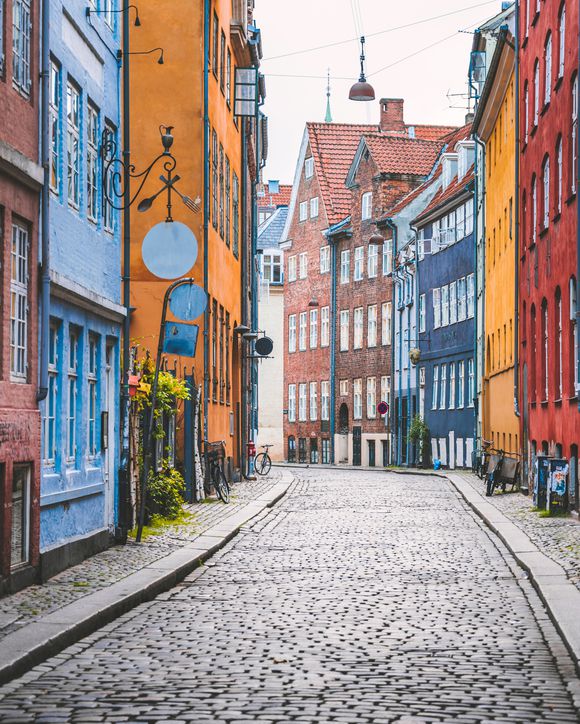 Narrow cobblestone alley with colorful houses in Copenhagen, Denmark