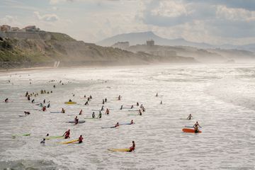 Surfers with colorful surfboards in calm water at Biarritz, France