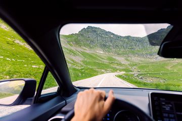 A man driving a car on a mountain road in Romania 