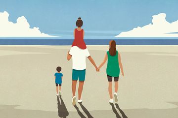 Affectionate family walking on tranquil sunny summer ocean beach