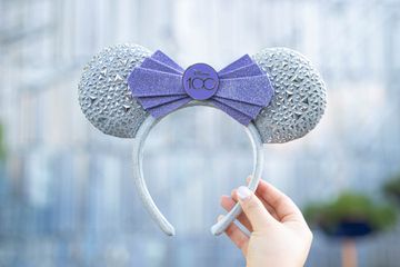 The Disneyland Minnie Mouse ears headband made for Disneyland castle decorated for the Disney100 Celebration