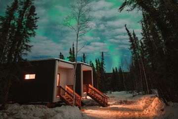 Exterior of the cube suites at the Borealis Basecamp in Alaska under the Northern Lights