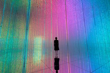 A person stands in the infinite crystal universe room 