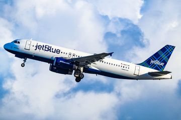 A JetBlue A320 airplane flying through the clouds 