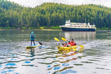A family kayaking and paddle boarding on a lake