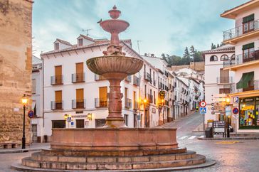 Spain, Malaga Province, Antequera. A view of San Sebastian square in the city center, early in the day, where it is located the church with that name and the street that leads to the old arabic castle or Alcazaba in the background.