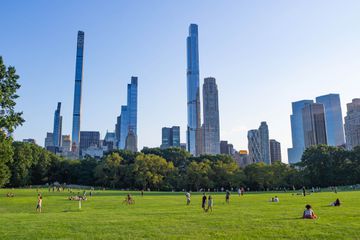 People in the in sheep's meadow surrounded by sky scrappers in NYC 