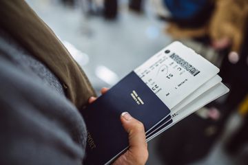 Womanâs hands holding passports & boarding passes 