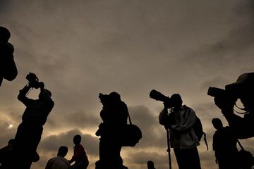 Indian photographers wait to capture solar eclipse images over Bangalore on July 22, 2009