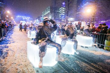 Parade performers on blocks of glowing ice during a nighttime parade at Quebec's Carnival