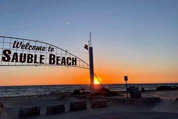 Sign over the beach "welcome to sauble beach" at sunset in Florida 