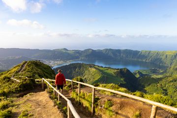 Hiker in a red jacket at the caldera on SÃ£o Miguel island in the Azores
