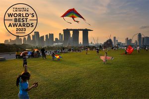 Families flying kites at Marina Barrage in Singapore with skyscrapers in the background 