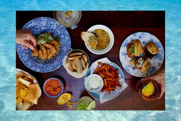 A photo of spread of Caribbean bar snacks placed on a Caribbean Sea background