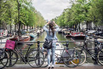 Female tourist taking a photo with smartphone in Amsterdam