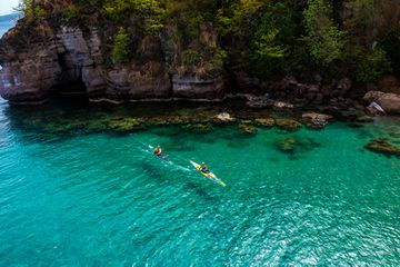 Two people kayak in the crystal clear waters