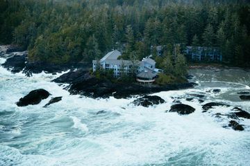 Aerial view of Wickannish Inn with a storm coming in and ocean waves crashing