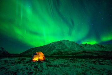 Tent camping under Northern Lights at Tombstone Territorial Park in Yukon, Canada